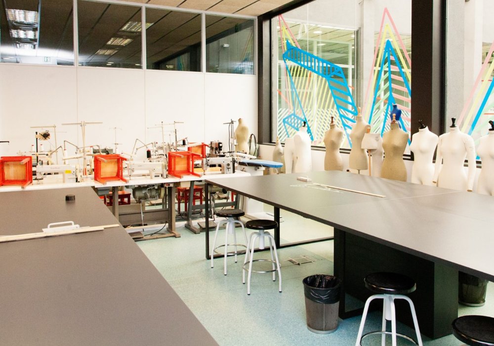 A room filled with numerous mannequins and stools.