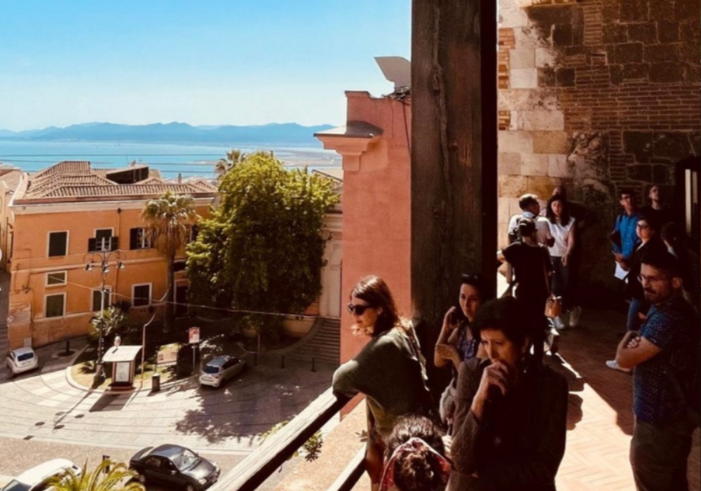 A group of people enjoying the view from a balcony.